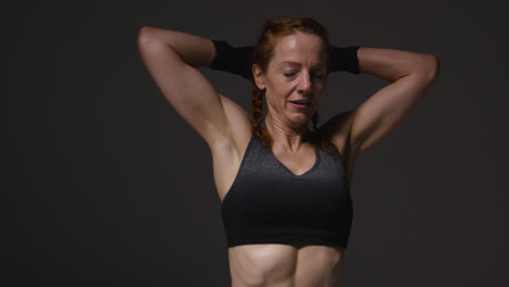 Studio-Shot-Of-Mature-Woman-Wearing-Gym-Fitness-Clothing-Doing-Mountain-Climber-Exercise-3